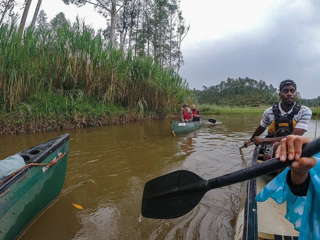 Kanu Ausflug auf Fluss durch üppig grüne Landschaft, nahe Ruhengeri, Northern Province, Ruanda, Afrika