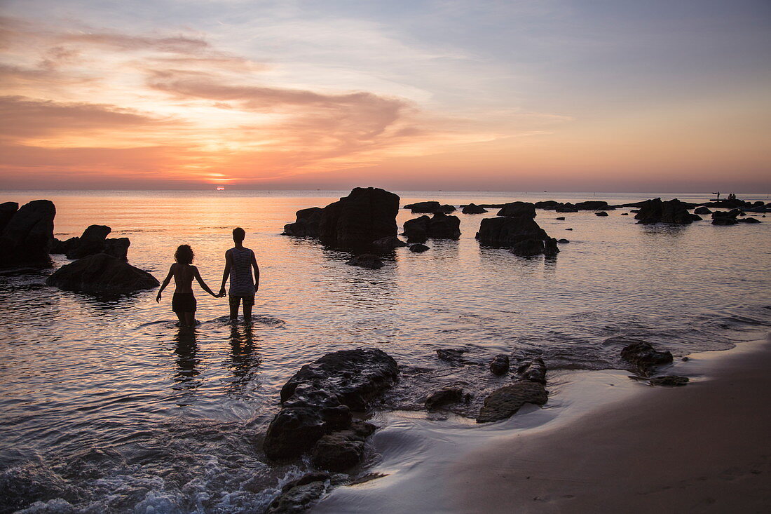 Silhouette von jungem Paar das Hände hält am Ong Lang Beach bei Sonnenuntergang, Ong Lang, Insel Phu Quoc, Kien Giang, Vietnam, Asien