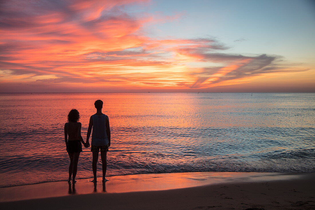 Silhouette von jungem Paar das Hände hält am Ong Lang Beach bei Sonnenuntergang, Ong Lang, Insel Phu Quoc, Kien Giang, Vietnam, Asien