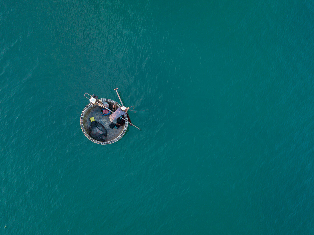 Luftaufnahme von Fischer in traditionellem runden Boot in türkisfarbenen Wasser, Ong Lang, Insel Phu Quoc, Kien Giang, Vietnam, Asien