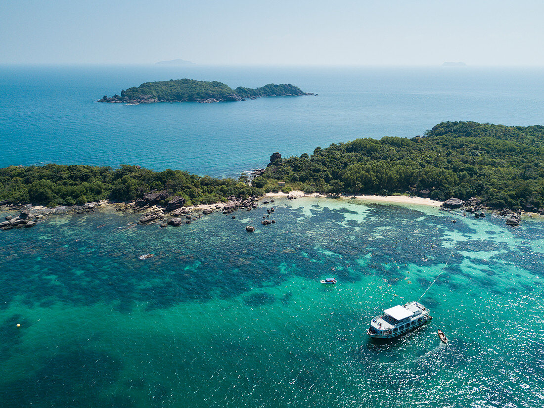 Luftaufnahme von John's Tours Nr. 9 Ausflugboot und Touristen die in klarem Wasser nahe Strand mit Kokospalmen schnorcheln, Dam Ngang Island, nahe Insel Phu Quoc, Kien Giang, Vietnam, Asien