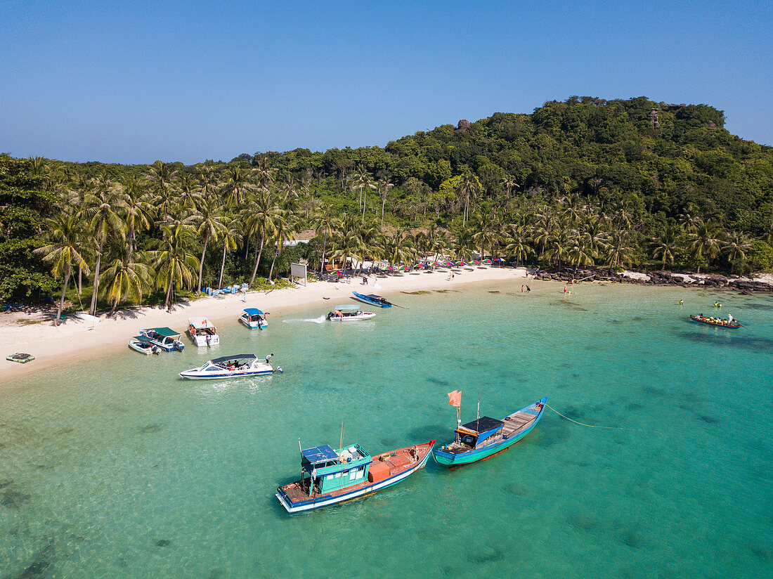 Aerial view of fishing boats moored in bay and beach with coconut palms, May Rut Island, near Phu Quoc Island, Kien Giang, Vietnam, Asia