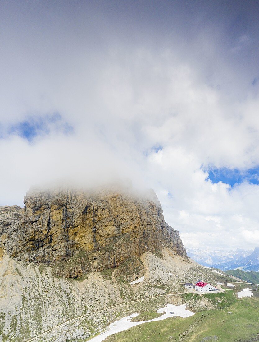 Aerial panoramic of clouds over Denti di Terrarossa (Rosszahne) and Alpe di Tires hut, Dolomites, Trentino Alto Adige, Italy