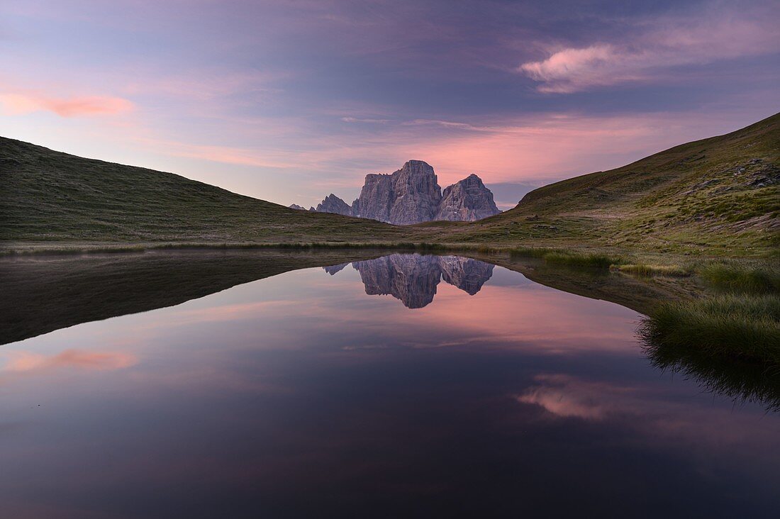 The Pelmo massif is reflected in Lake Baste at the first light of a summer day, Mondeval, Dolomites