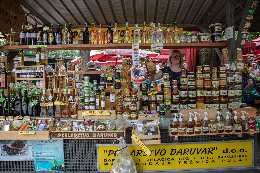 Frau verkauft lokale Spezialitäten an einem Marktstand, Pula, Istrien, Kroatien, Europa