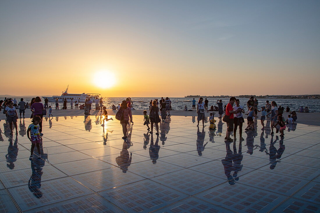Menschen versammeln sich auf dem herrlichen Denkmal zur Sonne bei Sonnenuntergang, Zadar, Zadar, Kroatien, Europa