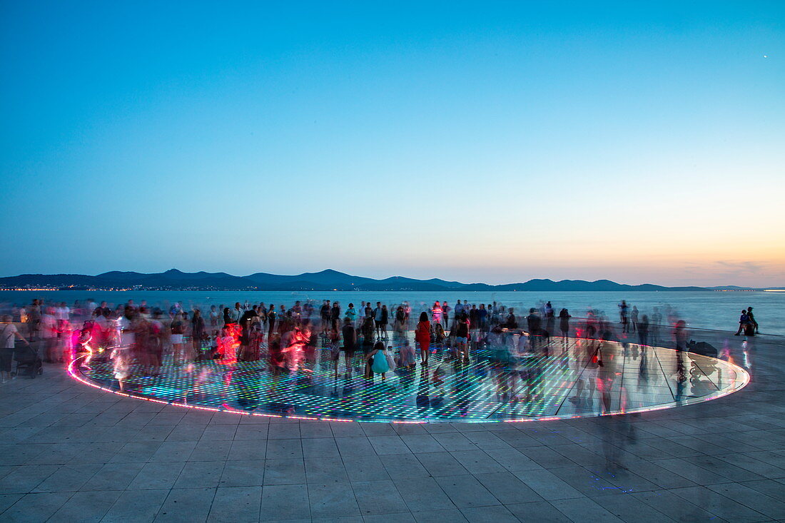 Menschen versammeln sich auf dem herrlichen Denkmal zur Sonne in der Abenddämmerung, Zadar, Zadar, Kroatien, Europa