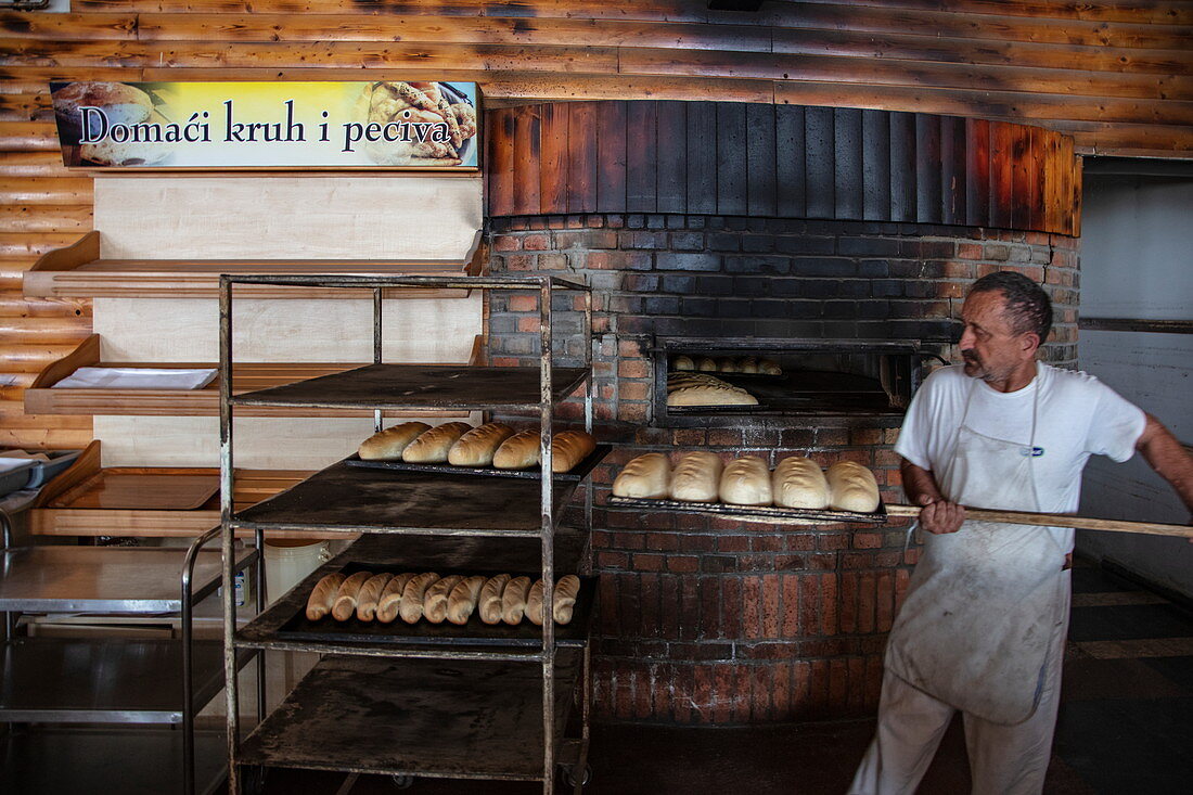 Baker with bread in the Macola restaurant, Korenika, Lika-Senj, Croatia, Europe