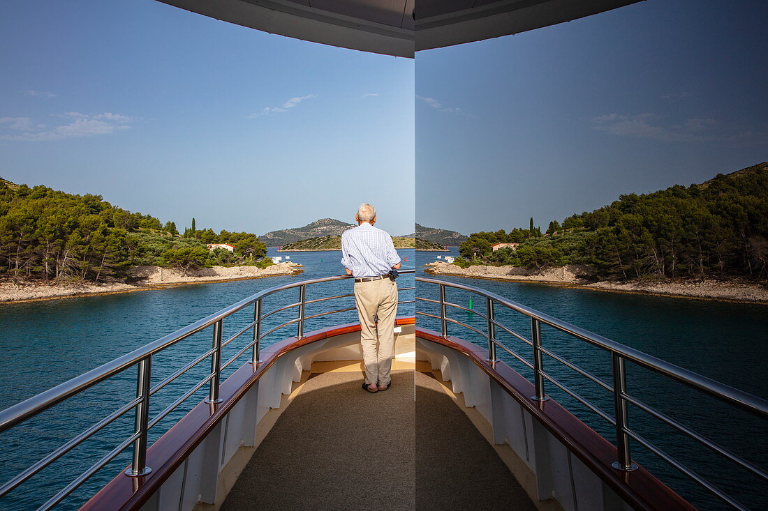 Spiegelung von Mann an Deck von Kreuzfahrtschiff mit Küste, Nationalpark Kornati-Inseln, Šibenik-Knin, Kroatien, Europa