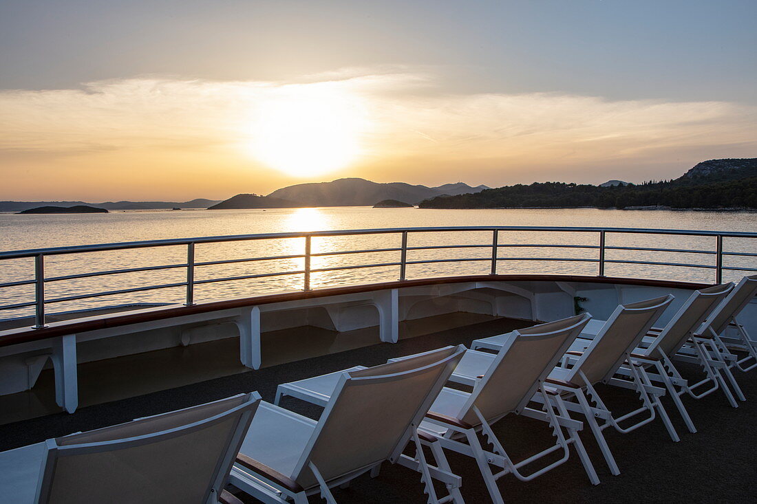 Liegestühle an Bord von Kreuzfahrtschiff bei Sonnenuntergang, nahe Kukljica, Zadar, Kroatien, Europa