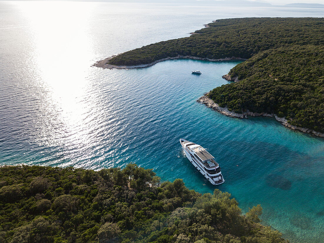 Luftaufnahme von Kreuzfahrtschiff in unberührter Bucht bei einem Halt zum Schwimmen für Passagiere, nahe Kampor, Primorje-Gorski Kotar, Kroatien, Europa