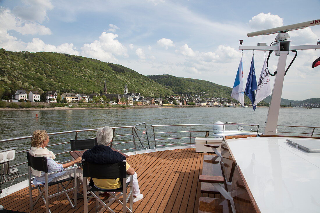 Paar auf Sonnendeck von Flusskreuzfahrtschiff während einer Kreuzfahrt auf dem Rhein, nahe Boppard, Rheinland-Pfalz, Deutschland, Europa