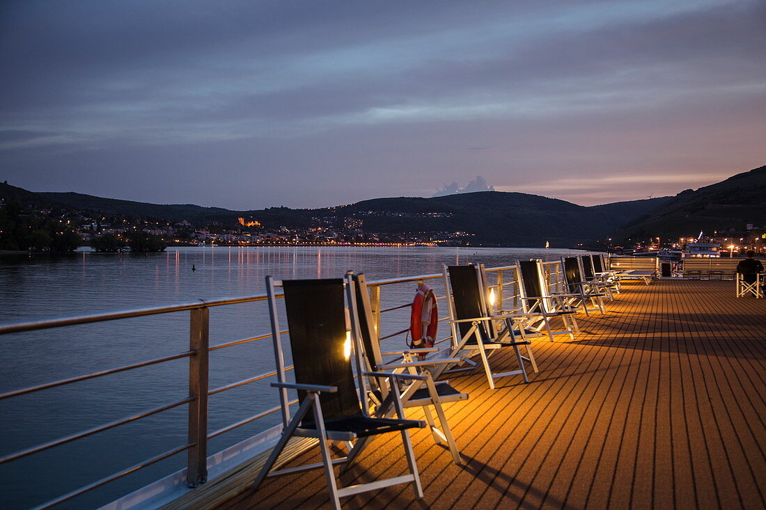 Chairs on sundeck of river cruise ship during a cruise on the Rhine at dusk, Ruedesheim am Rhein, Hesse, Germany, Europe