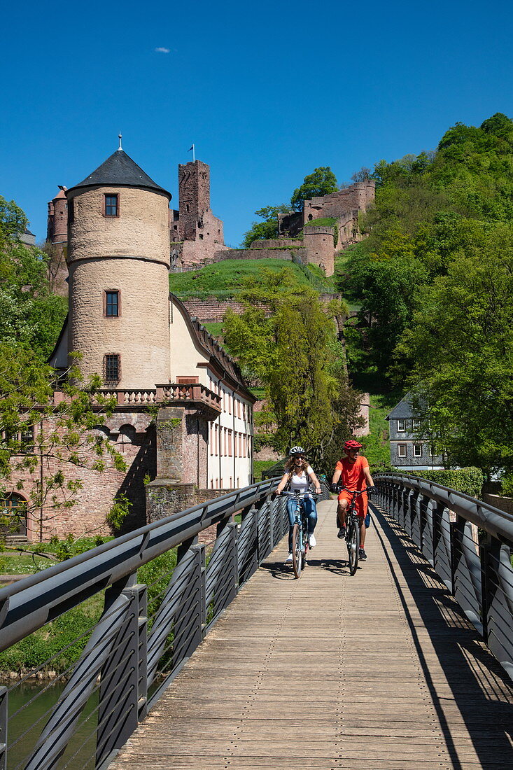Cyclists on bridge over the Tauber with the former Princely Court and White Tower of the city wall behind it, Wertheim, Spessart-Mainland, Franconia, Baden-Wuerttemberg, Germany, Europe