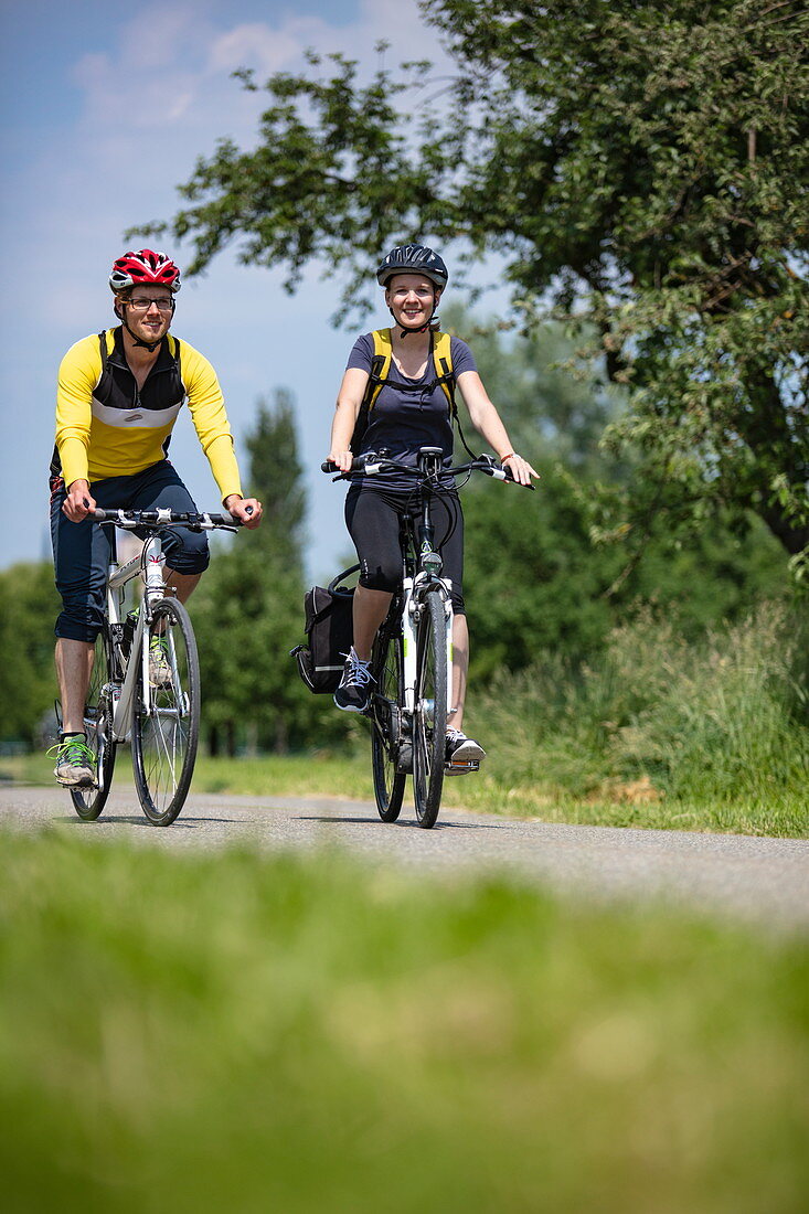 Young man and young woman ride mountain bikes, Tauberbischofsheim, Baden-Wuerttemberg, Germany, Europe