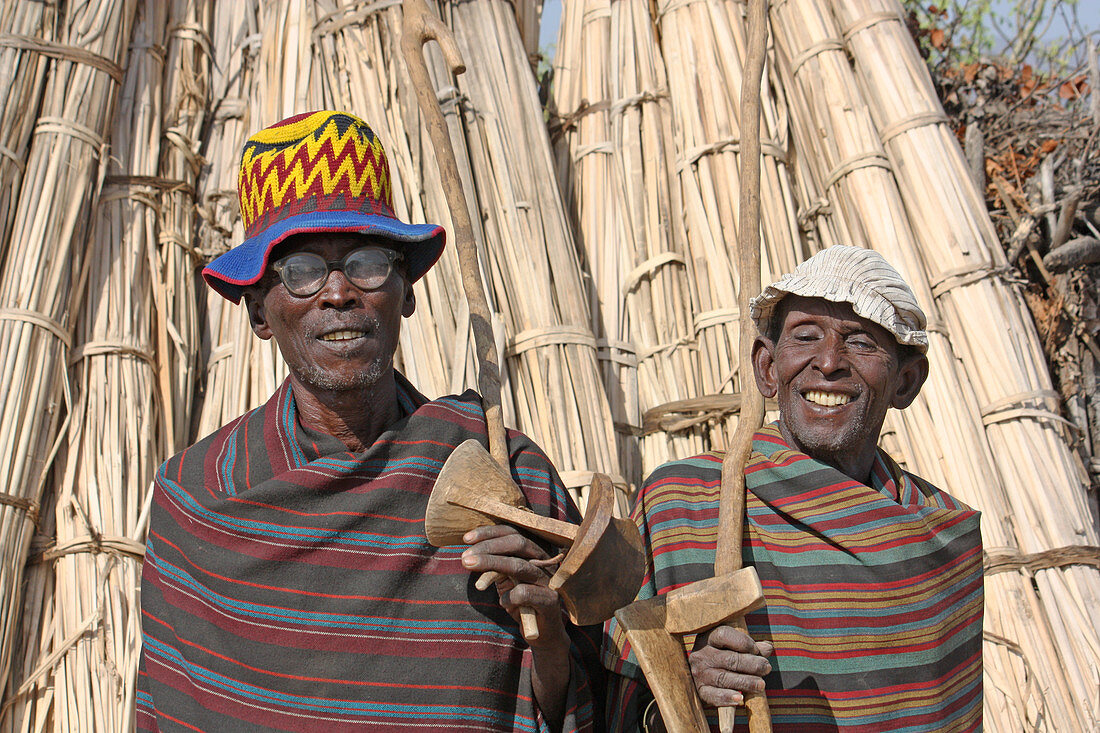 Äthiopien; südliches äthiopisches Hochland; zwei Männer vom Stamm der Arbore; mit typischen Umhängen und Kopfbedeckung; in den Händen lange Stöcke der Viehhirten und kleine Sitzschemelchen