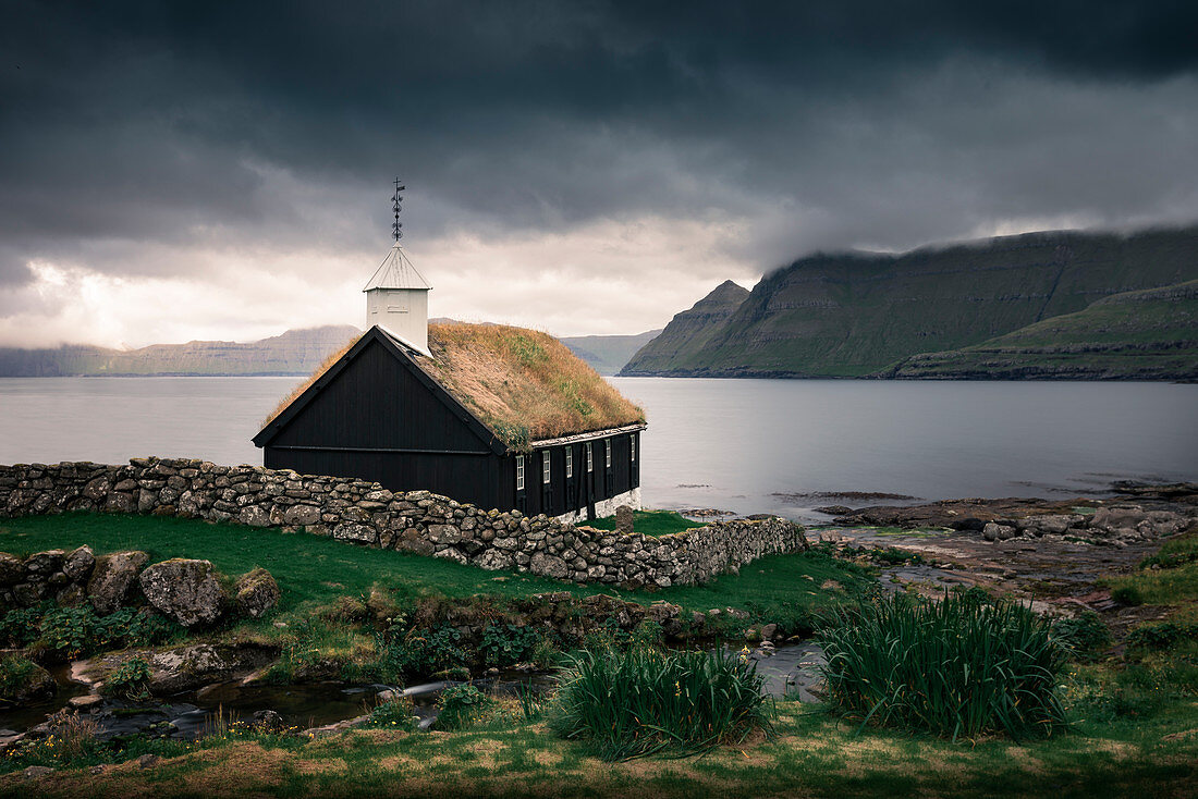 Church of the Funningur Parish on Eysturoy Island under dramatic clouds, Faroe Islands