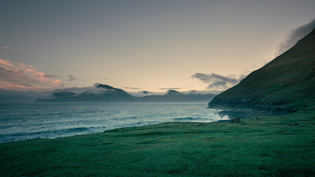 Bay in Gjogv on Eysturoy with a view of Kalsoy Island in sunset, Faroe Islands