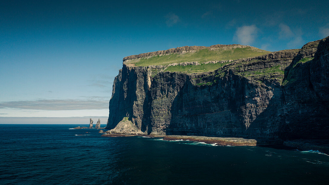 Felsen Risin og Kellingin auf Färöer Inseln am Tag bei Sonne und blauem Himmel\n