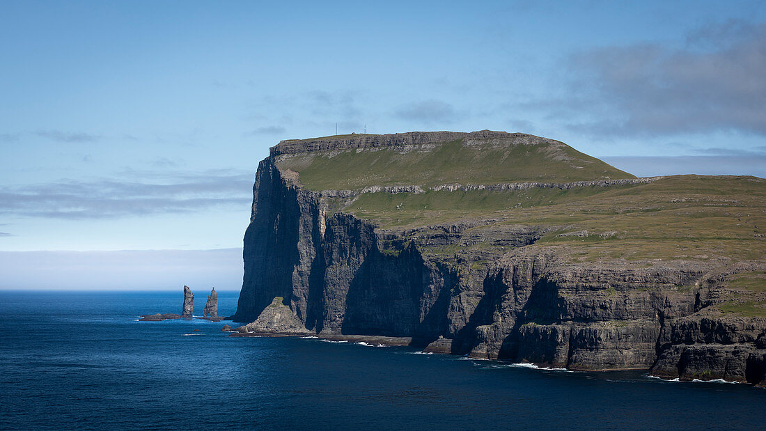 Felsen Risin og Kellingin auf Färöer Inseln am Tag bei Sonne und blauem Himmel\n