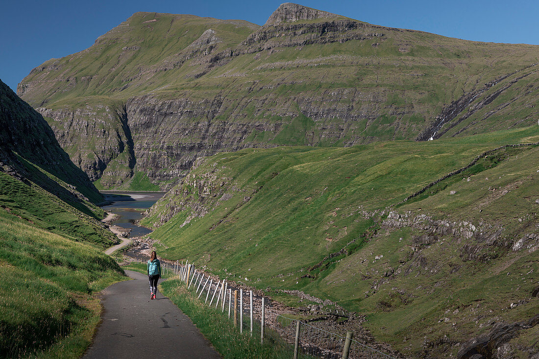 Woman on hiking trail in Saksun Bay, Streymoy, Faroe Islands