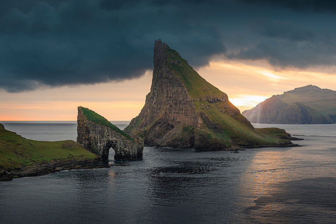 Felsformationen von Drangarnier und Insel Tindholmur im Sonnenuntergang auf Vagar, Färöer Inseln\n