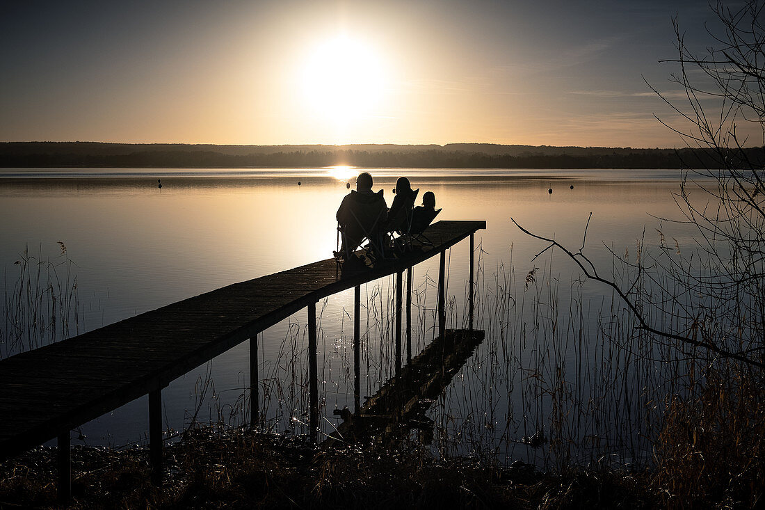 Blick auf einen Steg mit Menschen die den Sonnenuntergang geniessen, Fünfseenland, Oberbayern, Bayern, Deutschland, Europa