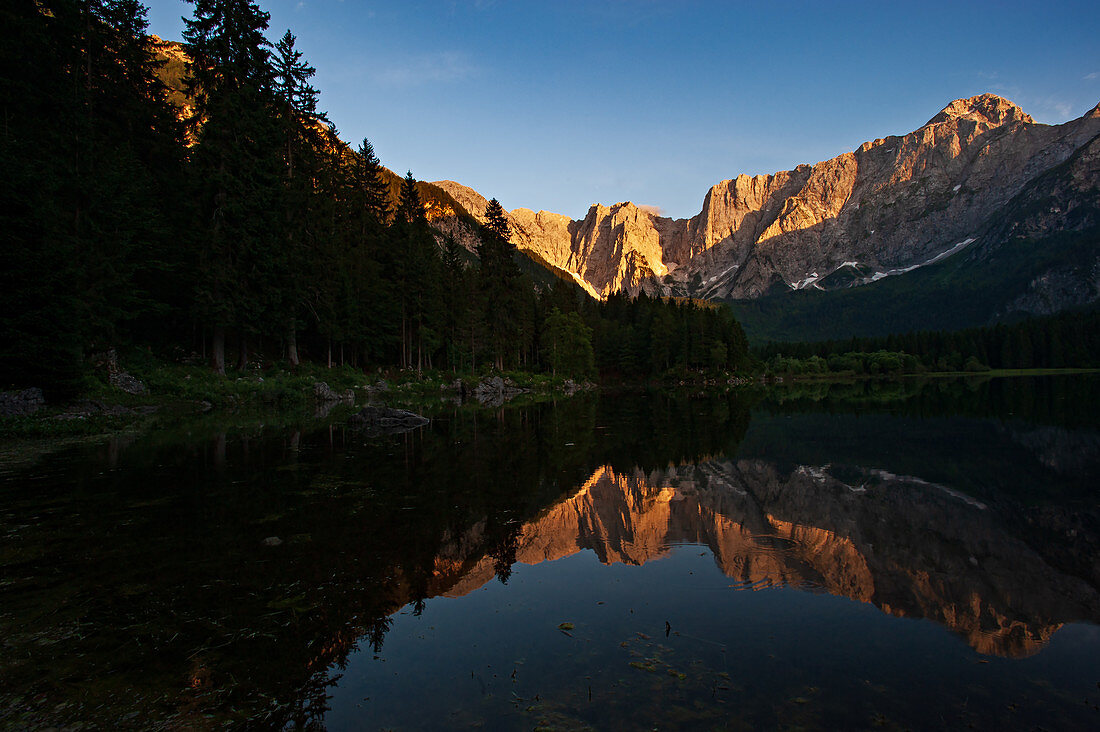 Der Fusine See ist eiszeitlichen Ursprungs und einer der schönsten in den julianischen Alpen. Im Hintergrund die Berggruppe des Berg Mangart, die die Grenze zu Slowenien markiert. Italien.