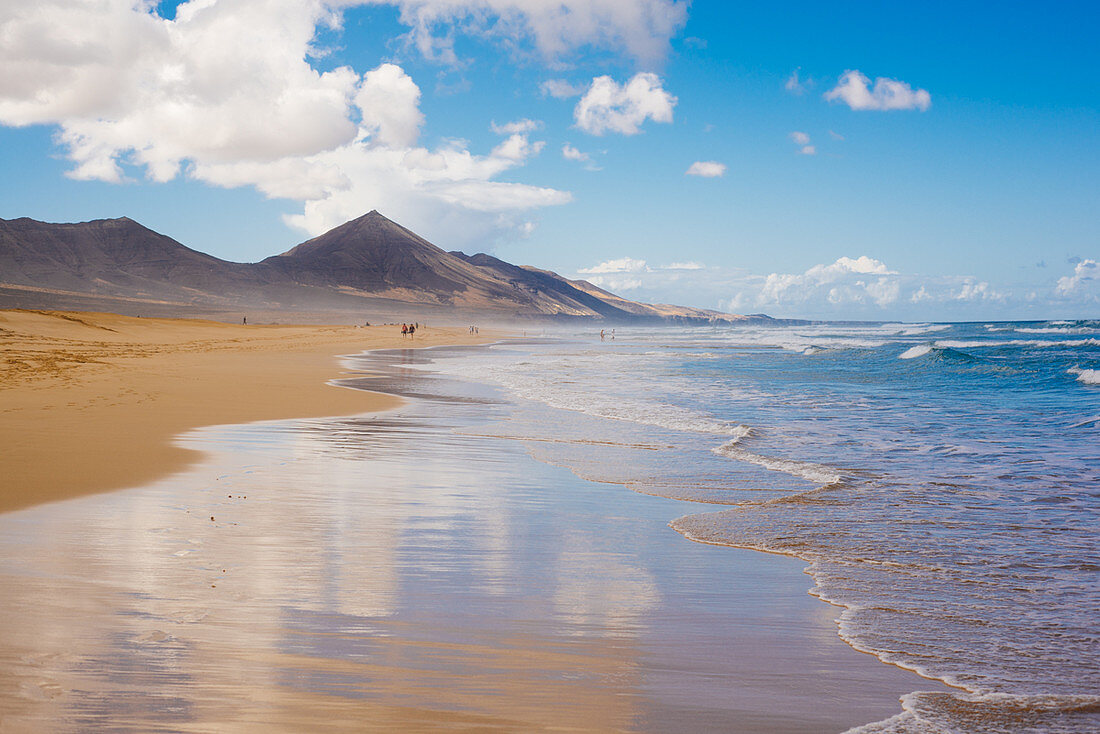 View along a sandy beach on Fuerteventura on a cloudy day.