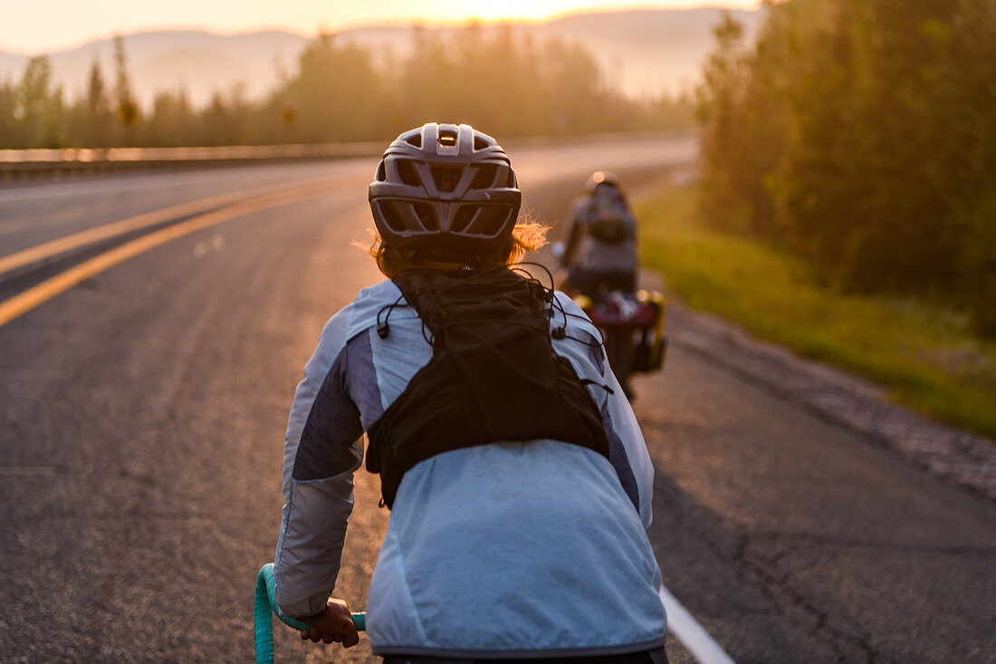 Cyclists on road at sunset, Ontario, Canada
