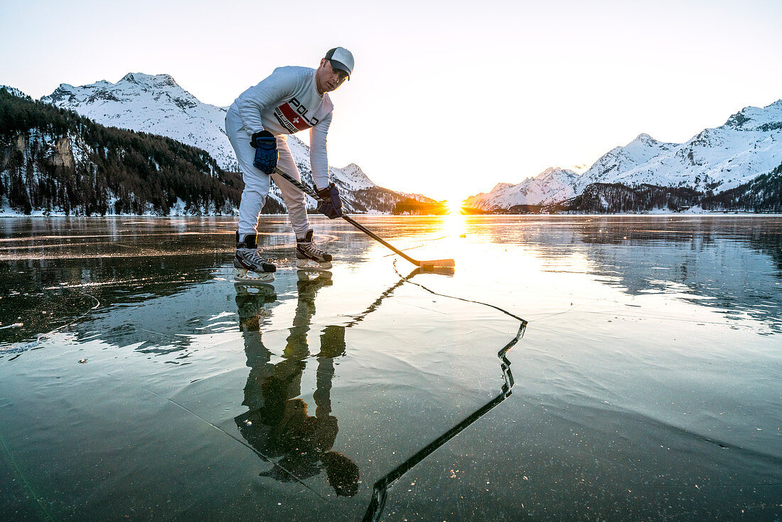 Eishockeyspieler auf rissiger Oberfläche des gefrorenen Sils-Sees, Engadin, Kanton Graubunden, Schweiz, Europa
