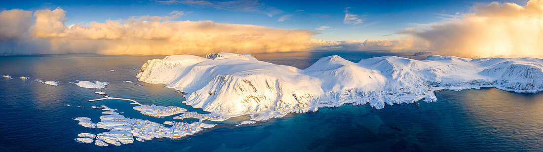 Arktischer Sonnenaufgang auf schneebedeckten Bergen und kaltem Meer, Luftbild, Sorvaer, Soroya-Insel, Troms og Finnmark, Arktis, Norwegen, Skandinavien, Europa