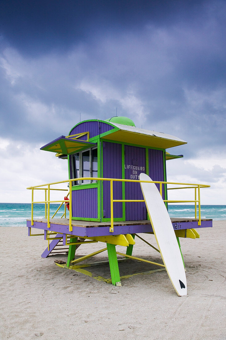 Wooden colourful lifeguard hut on a sandy beach.