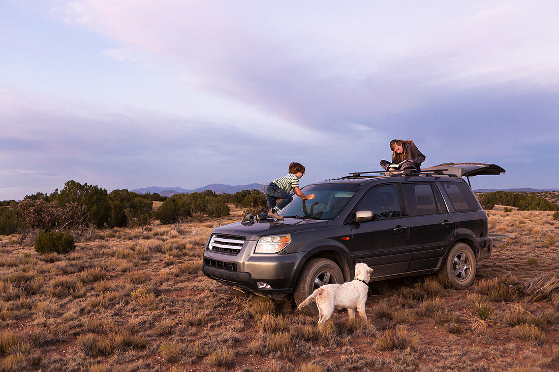 Kinder auf SUV bei Sonnenuntergang, Galisteo-Becken, Santa Fe