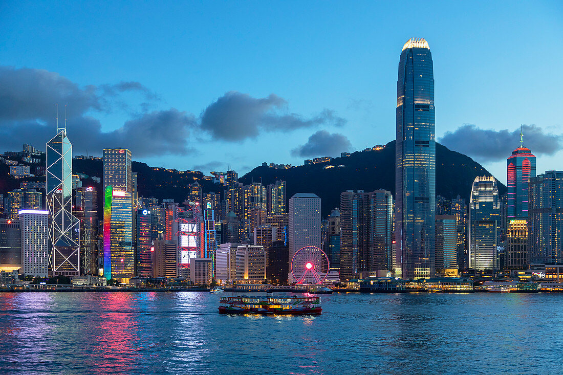Star Ferry in Victoria Harbour and skyline of Hong Kong Island at dusk, Hong Kong, China, Asia