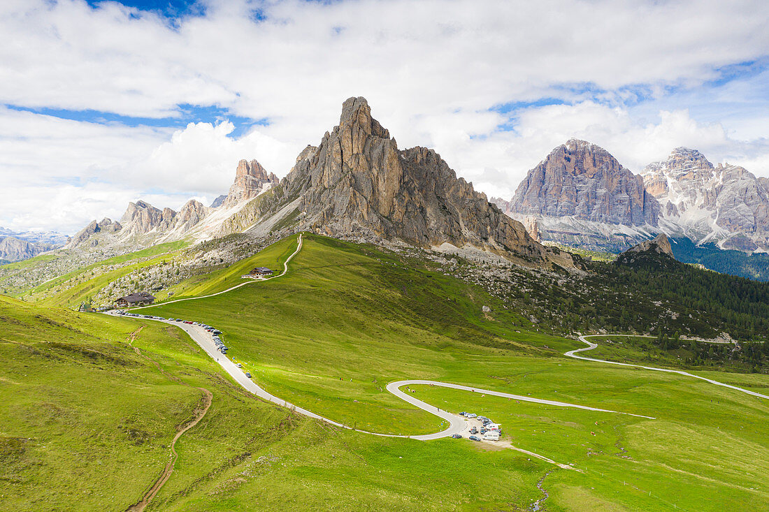 Winding road of Giau Pass in the green landscape with Ra Gusela and Tofane mountains in background, Dolomites, Veneto, Italy, Europe