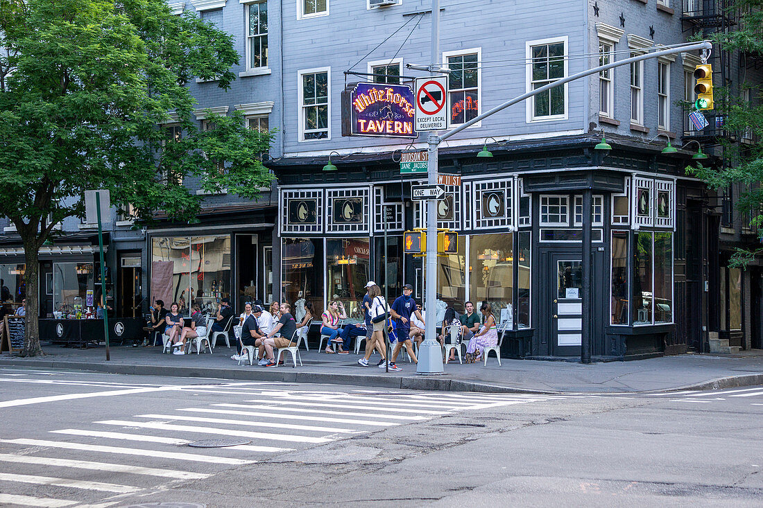 Gruppe von Leuten, die auf Bürgersteig vor White Horse Tavern, New York City, New York, USA sitzen