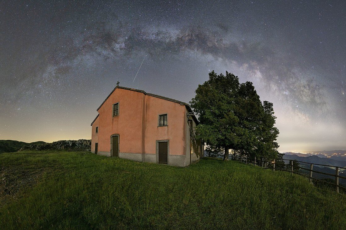 Der Milchstraßenbogen beleuchtet den Himmel in Sommernächten über der Kirche von Nostra Signora del Dragnone, Gemeinde Zignago, Provinz La Spezia, Distrikt Ligurien, Italien, Europa