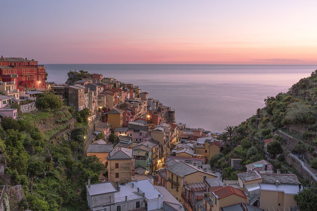 Ein Panoramablick auf das Dorf Manarola während eines farbenfrohen Sonnenuntergangs im späten Frühling, Nationalpark Cinque Terre, Unesco-Weltkulturerbe, Gemeinde Riomaggiore, Provinz La Spezia, Distrikt Ligurien, Italien, Europa