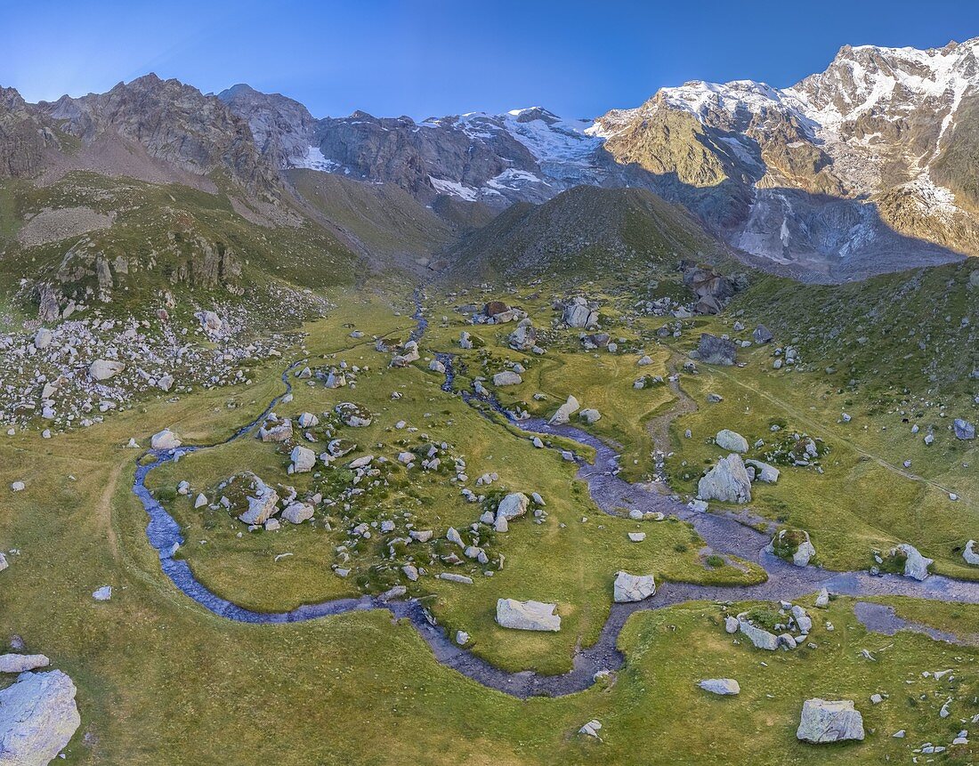 Aerial view of the Alpe Pedriola and it's winding rivers with the east face of Mount Rosa massif in the back. Macugnaga, Anzasca Valley, Verbano Cusio Ossola province, Piedmont, Italy, Europe.