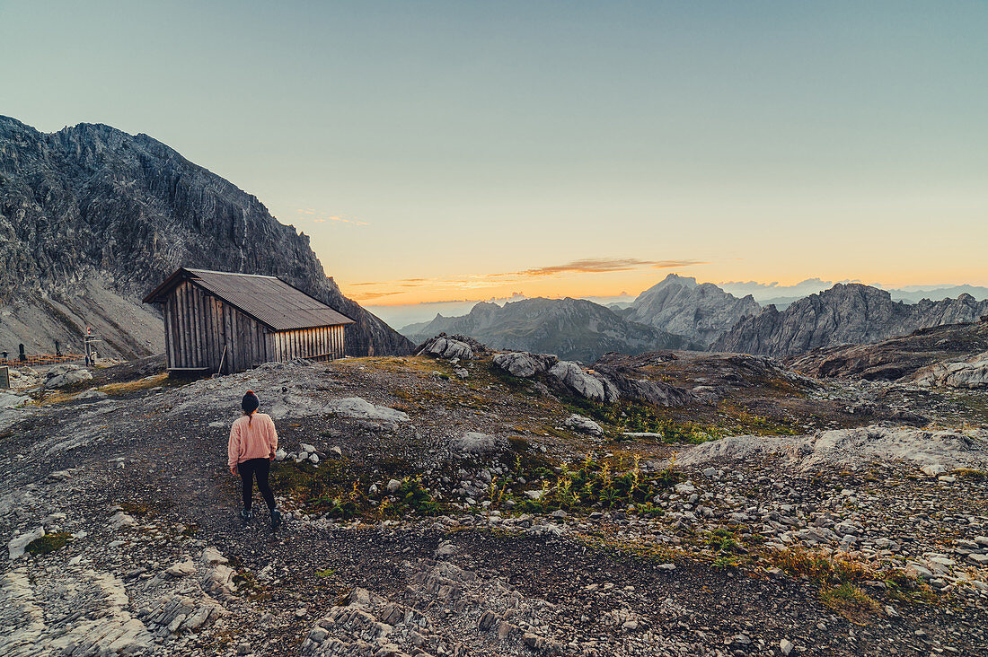 Frau genießt Sonnenaufgang in den Bergen im Rätikon, Vorarlberg, Österreich, Europa