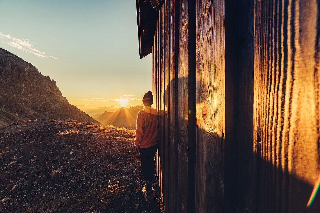 Frau genießt Sonnenaufgang in den Bergen im Rätikon, Vorarlberg, Österreich, Europa