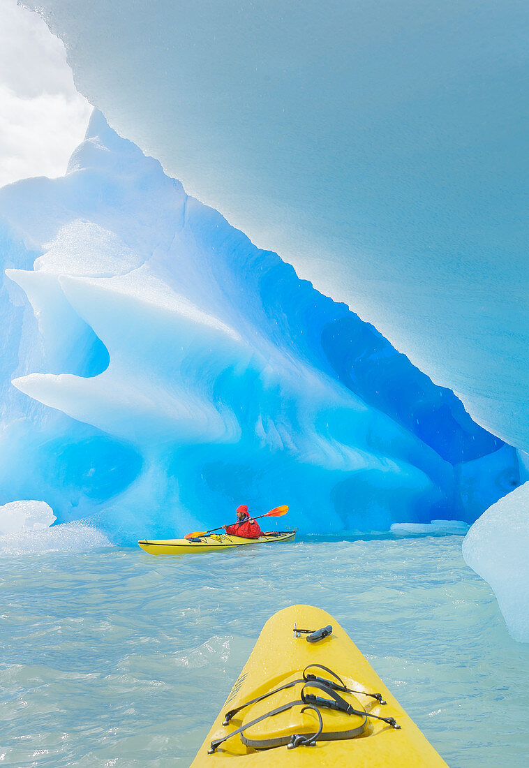 Kayaker paddling near icebergs, Torres del Paine National Park, Chile, South America