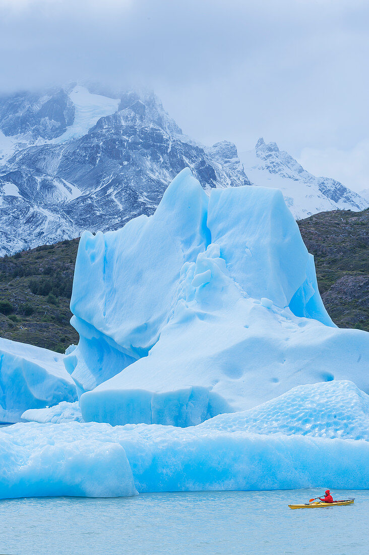 Kayaker paddling among icebergs, Torres del Paine National Park, Patagonia, Chile, South America