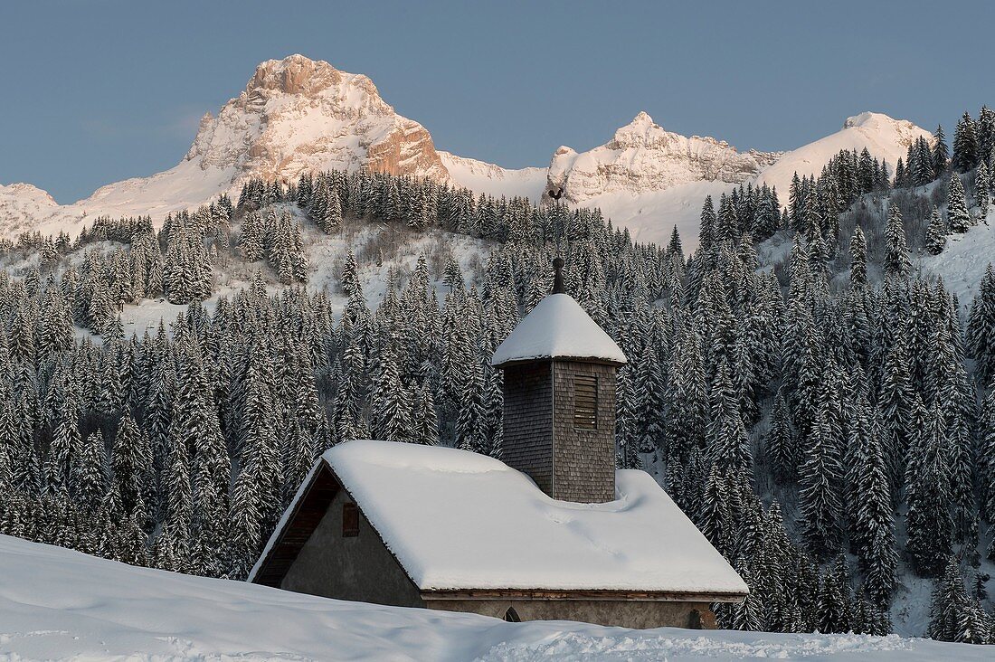 Frankreich, Haute Savoie, Le Grand Bornand, die Kapelle der Duche unter dem Schnee und Percée Point in der Abenddämmerung