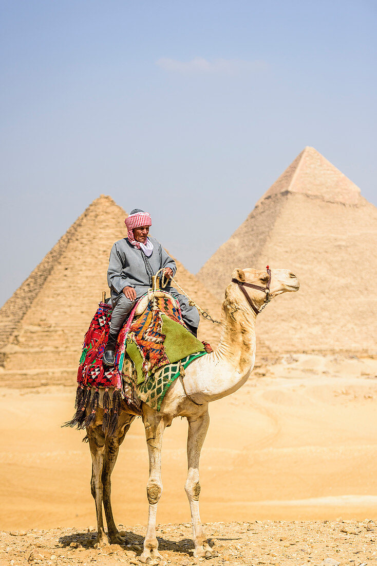 Drei Pyramiden, Denkmäler und Grabstätten der Pharaonen Khufu, Khafre und Menkaure, eines Touristenführers, der auf einem Kamel reitet