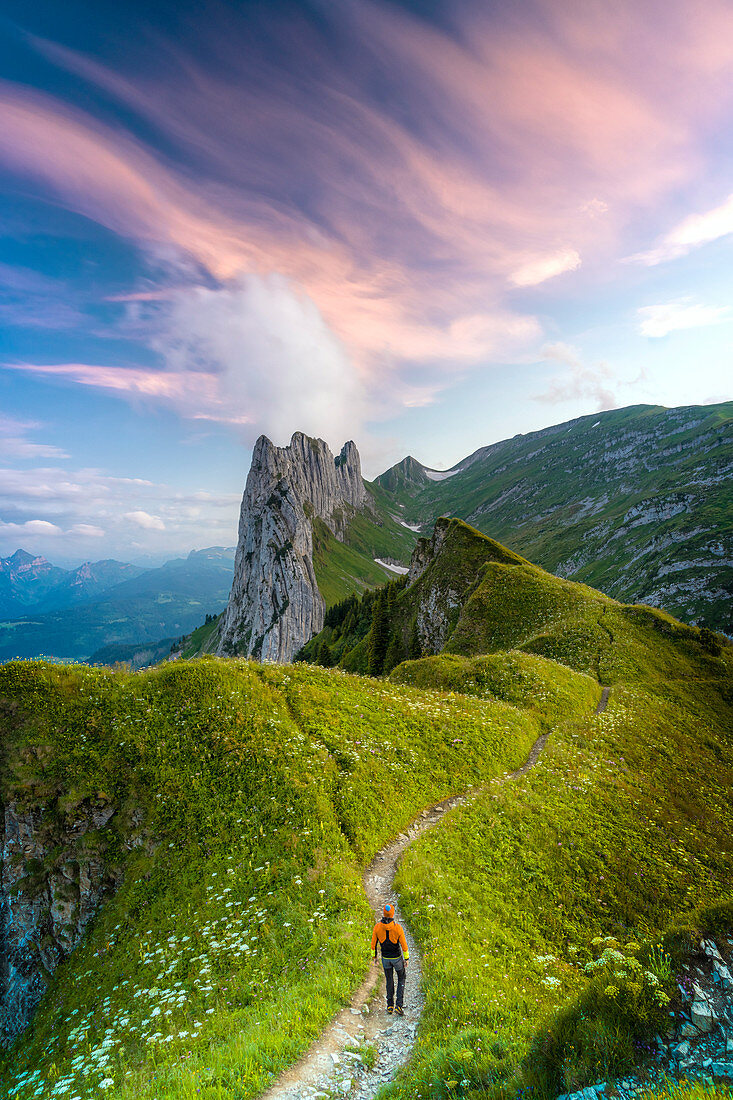 Wanderermann, der auf Fußweg in Richtung Saxer Lucke bei Sonnenuntergang, Kanton Appenzell, Alpstein Range, Schweiz, Europa geht