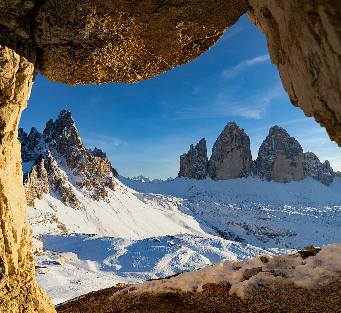 Sonnenuntergang über den schneebedeckten Tre Cime di Lavaredo und Monte Paterno gesehen von Felsenhöhle, Sesto Dolomiten, Südtirol, Italien, Europa