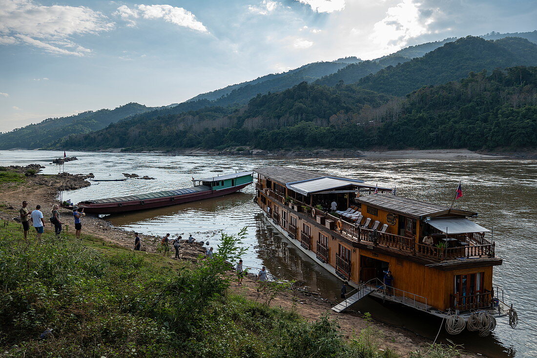Passengers board the Mekong Sun river cruise ship on the banks of the Mekong River, Pak Tha District, Bokeo Province, Laos, Asia