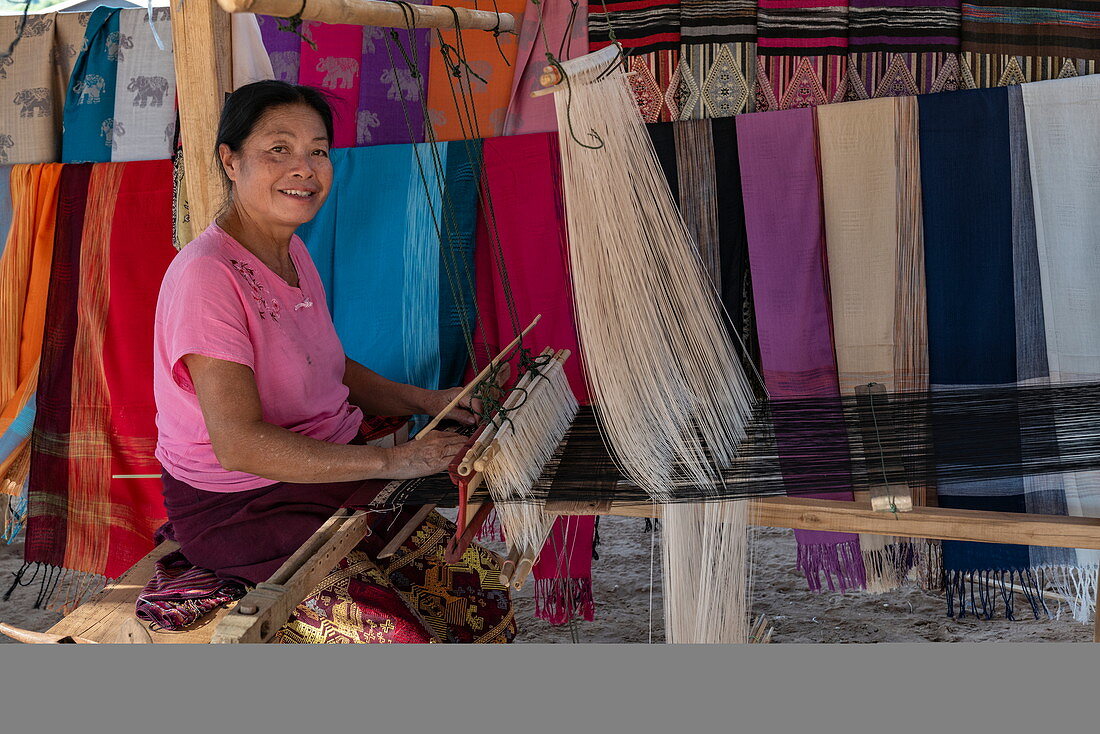 Frau webt Seidenschals auf einem Webstuhl auf einem lokalen Markt, Pak Ou, Provinz Luang Prabang, Laos, Asien